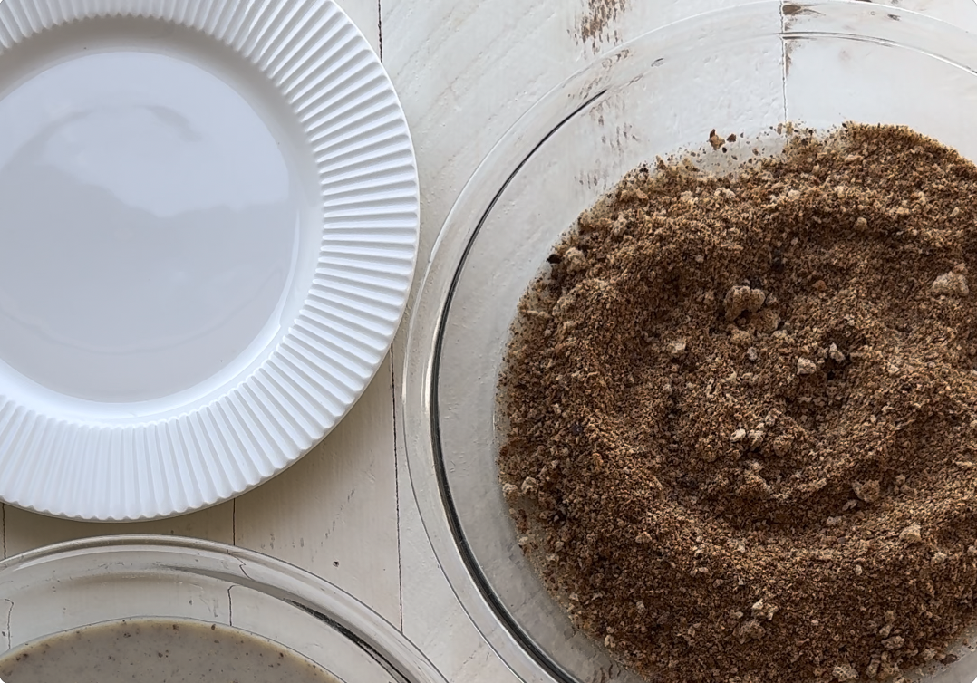 Sprouted breadcrumb breading station with plate, breadcrumbs, and plant-based egg